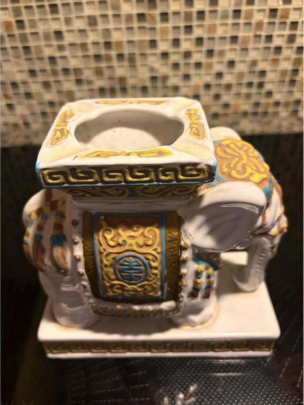 This is a vintage mid-century ceramic elephant ashtray with polychrome glaze.